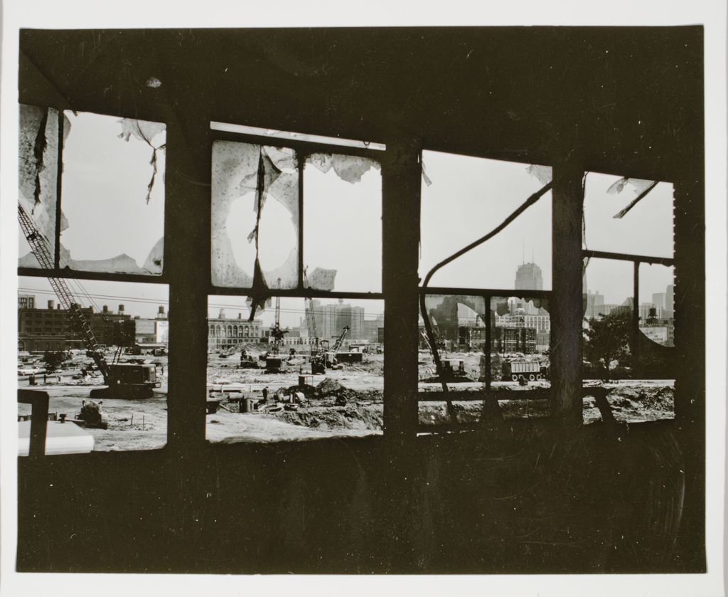 View through the window of a torn-down building of the construction of UIC east campus. Chicago skyline in distance